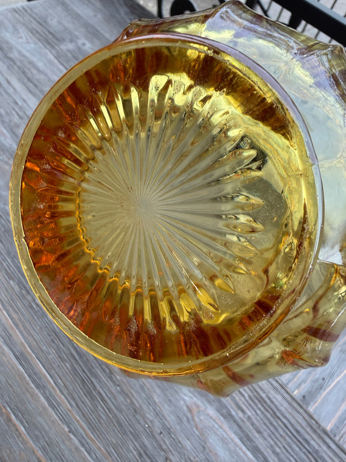 Clear glass ashtray with a textured bottom on a wooden surface