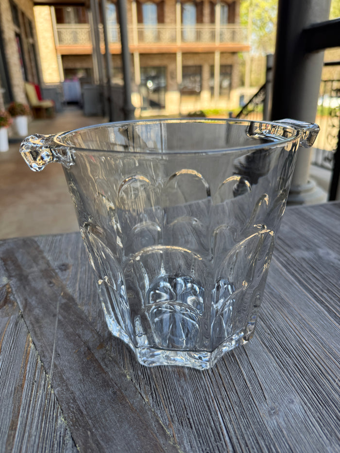 Clear glass bowl with intricate designs on a textured surface