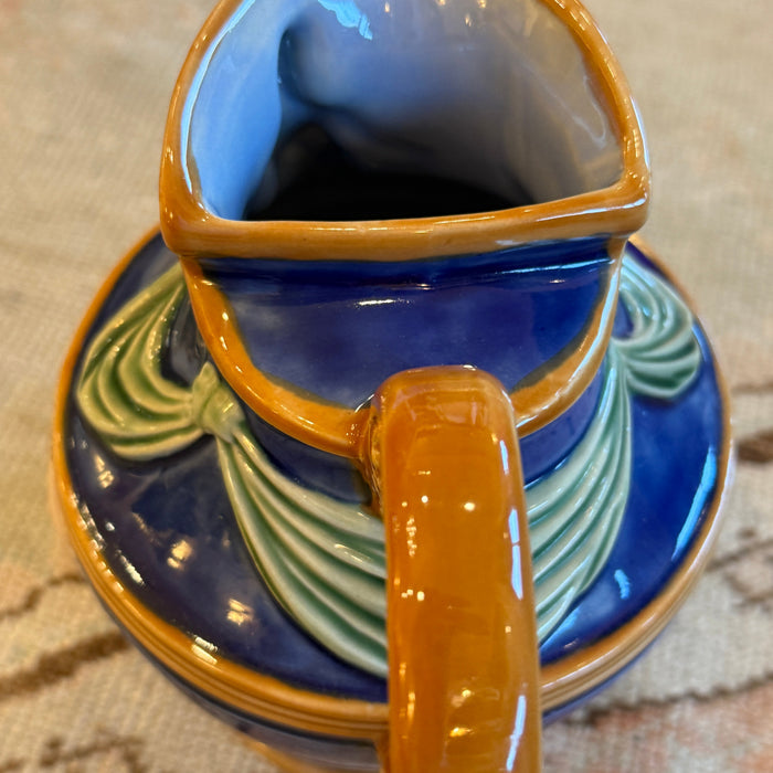Ceramic mug with a decorative handle on a textured surface