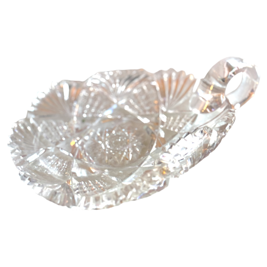 Clear glass candy dish with leaf design on a white background