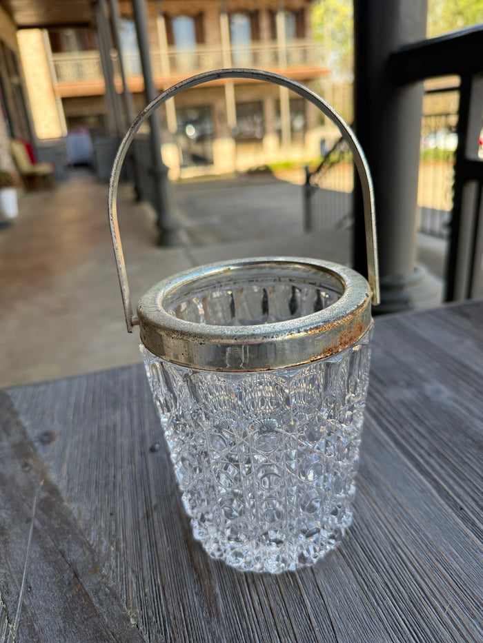 Clear glass object with metal base on a textured surface
