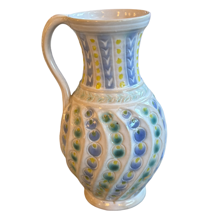 Ceramic pitcher with decorative patterns on a white background