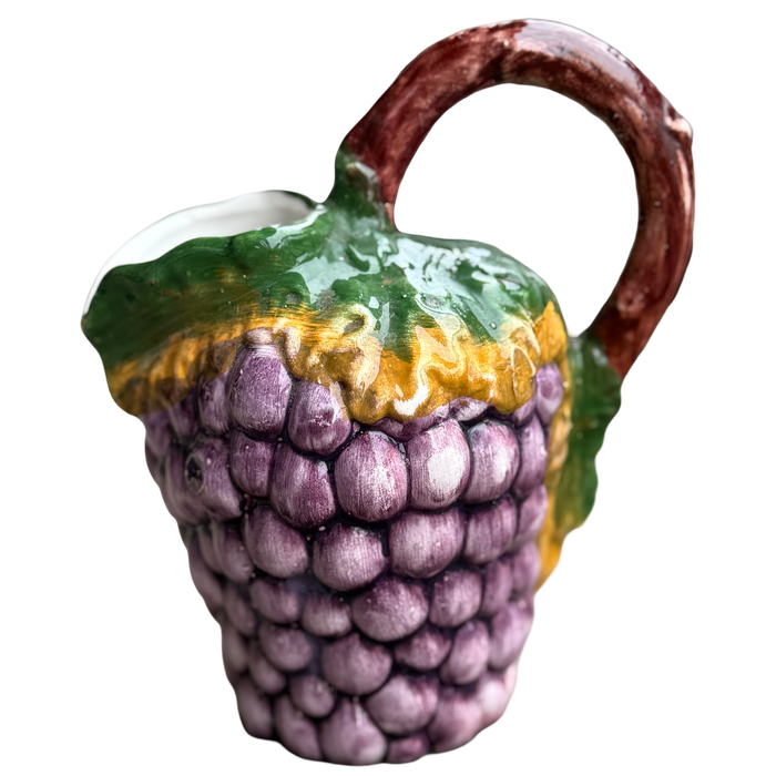 Ceramic teapot shaped like an acorn with purple grapes on a white background