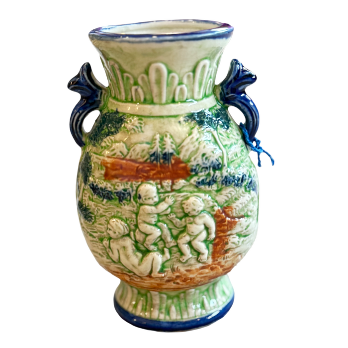 Decorative ceramic vase with cherubic figures and blue handles on a white background