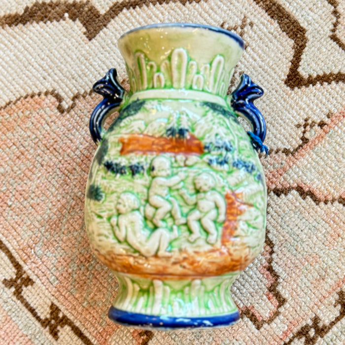 Decorative ceramic vase with intricate designs on a textured surface