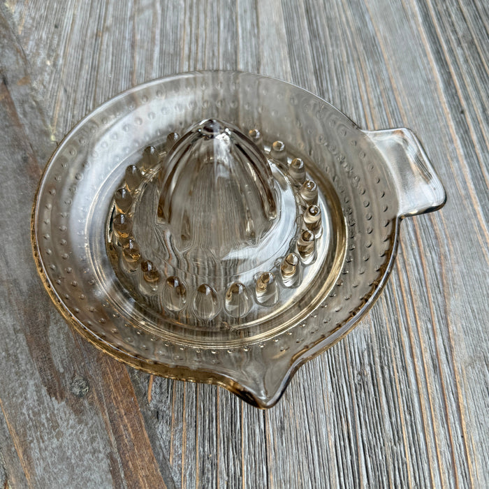Clear glass juicer lid on a wooden surface