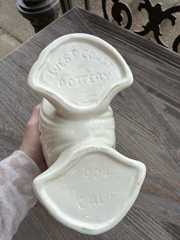 White ceramic duck-shaped container with 'W. H. Potter & Co.' branding on a wooden surface.