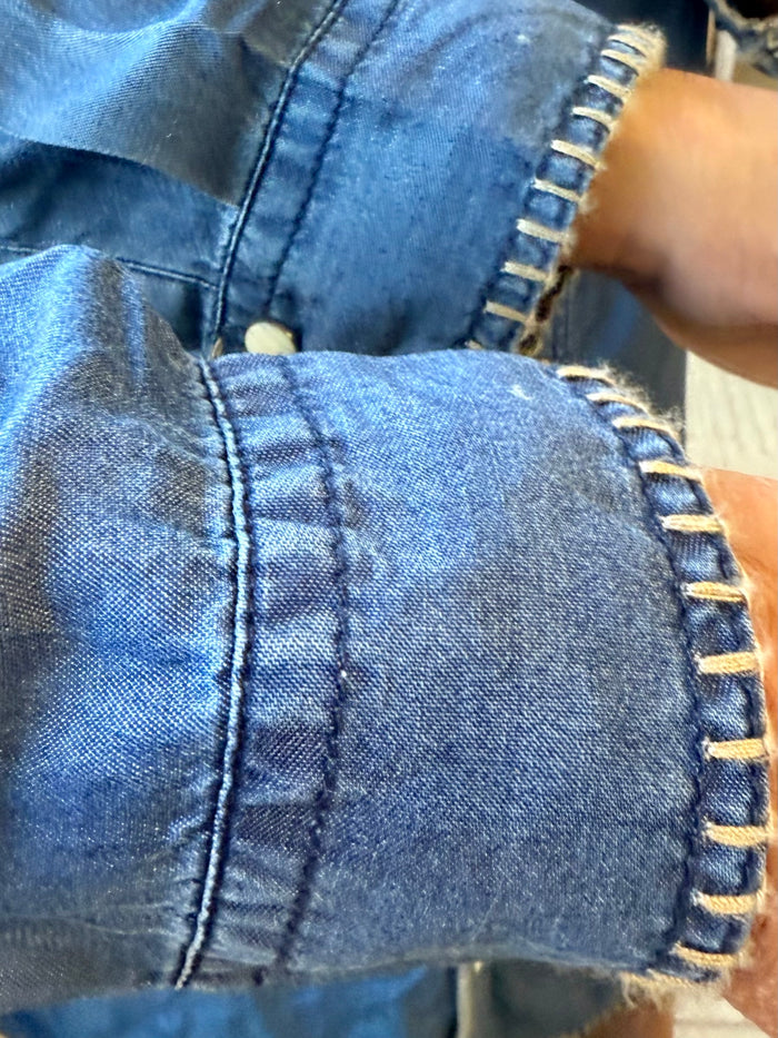 Blue denim whip-stitch seam detail with contrast topstitching