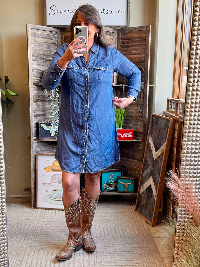 Blue denim snap-front dress with whip-stitched seams and long sleeves